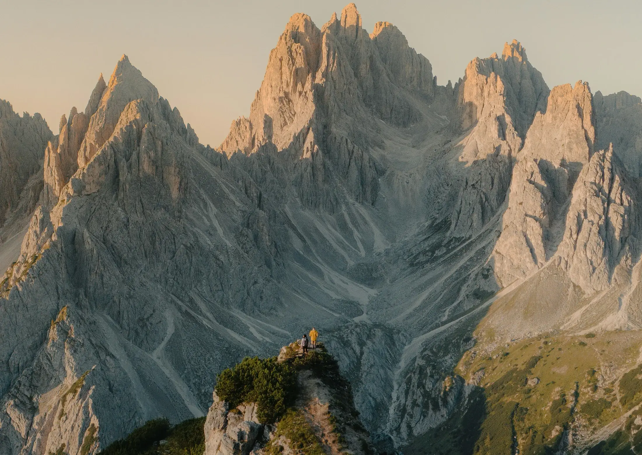 Dos personas en la cresta de una montaña frente a los picos