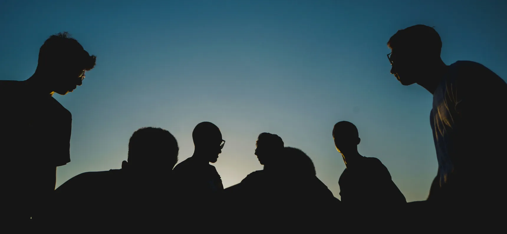 Siluetas de un grupo de personas contra el cielo